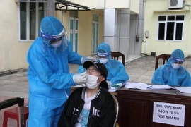 Nhân viên y tế lấy mẫu xét nghiệm. (Ảnh: Văn Tý/TTXVN)