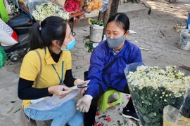 Nhân viên Bưu điện Hà Nội tư vấn cho người lao động tự do tham gia bảo hiểm xã hội tự nguyện. (Ảnh: TTXVN phát)