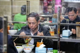 Các cửa hàng ăn uống lắp vách ngăn đảm bảo an toàn phòng chống dịch tạo được cảm giác an tâm cho khách hàng. (Ảnh: Thành Đạt/TTXVN)