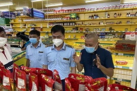 Ông Trương Văn Ba, Cục trưởng Cục Quản lý thị trường Thành phố Hồ Chí Minh (ở giữa) làm việc với đại diện Công ty Bách Hóa Xanh tại một buổi kiểm tra. (Ảnh: Thành Chung/TTXVN)