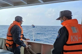 Tàu Kiểm ngư lai dắt tàu ngư dân mắc cạn. (Ảnh: TTXVN phát)