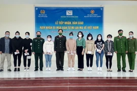 Bàn giao 14 nạn nhân bị mua bán sang Myanmar về Việt Nam. (Ảnh: TTXVN phát)