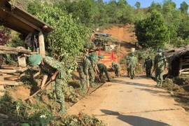 Cán bộ, chiến sỹ thuộc Tiểu đoàn bộ binh (Trung đoàn 741, Bộ Chỉ huy Quân sự tỉnh Điện Biên) phát quang đường liên bản, khơi thông cống rãnh thoát nước, tạo diện tạo đường giao thông nông thôn sạch sẽ, đảm bảo vệ sinh. (Ảnh: Xuân Tiến/TTXVN)