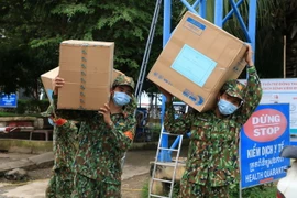 Bộ đội Biên phòng Đồng Tháp hỗ trợ vận chuyển 50.000 khẩu trang và 500 bộ đồ bảo hộ y tế trị giá hơn 90 triệu đồng trao tặng thanh niên tỉnh Prey Veng của Campuchia để phòng, chống dịch COVID-19. (Ảnh: Chương Đài/TTXVN)