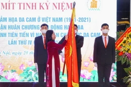 Phó Chủ tịch nước Võ Thị Ánh Xuân gắn Huân chương Lao động hạng Ba lên lá cờ truyền thống của Hội Nạn nhân chất độc da cam/dioxin Việt Nam. (Ảnh: Tuấn Đức/TTXVN)