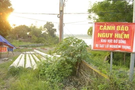 Chính quyền làm biển cảnh báo nguy hiểm tại khu vực sạt lở thôn Trung Hà, xã Thái Hòa, huyện Ba Vì. (Ảnh: Mạnh Khánh/TTXVN)