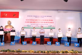 Thạc sỹ, Bác sỹ Chuyên khoa II Lê Anh Tuấn, Phó Giám đốc Bệnh viện Hồi sức chuyên sâu COVID-19 trao quà tri ân các tình nguyện viên tôn giáo sau khi hoàn thành công tác hỗ trợ tuyến đầu chống dịch. (Ảnh: Xuân Khu/TTXVN)