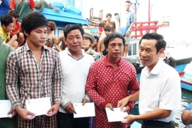 Đại diện Liên đoàn Lao động tỉnh Khánh Hòa thăm hỏi, hỗ trợ ngư dân gặp nạn. (Ảnh: Nguyên Lý/TTXVN)