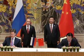 Đại diện tập đoàn Gazprom và đối tác Trung Quốc ký kết thỏa thuận hợp tác dưới sự chứng kiến của Tổng thống Nga Putin và Chủ tịch Trung Quốc Tập Cận Bình. (Nguồn: AFP/TTXVN)