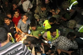 Nhân viên cứu hộ chuyển thi thể các nạn nhân tại hiện trường vụ đánh bom kinh hoàng ở Liban hôm 12/11/2015. (Ảnh: AFP/TTXVN)