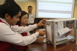 Kiểm tra hòm phiếu đấu thầu trái phiếu chính phủ. (Ảnh: TTXVN)