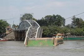 Chiếc sà lan bị chết máy đã đâm sập 2 nhịp giữa Cầu Ghềnh bắc qua sông Đồng Nai. (Ảnh: Sỹ Tuyên/Vietnam+)