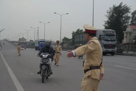 Cảnh sát giao thông kiểm tra phương tiện vị phạm. (Ảnh: TTXVN) 