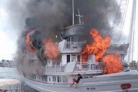 Du khách hốt hoảng nhảy khỏi con tàu cháy. (Ảnh: Nguyễn Hoàng/Vietnam+)
