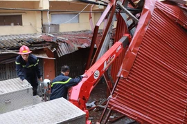 Lực lượng cứu hộ bất chấp nguy hiểm, cắt sắt mở đường. (Ảnh: Minh Sơn/Vietnam+)