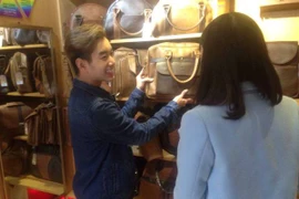 Nguyễn Đức Anh giới thiệu sản phẩm cho khách tại cửa hàng. (Ảnh: Phương Anh/Vietnam+)