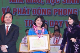 Phó Chủ tịch nước Đặng Thị Ngọc Thịnh và Bộ trưởng Bộ Giáo dục và Đào tạo Phùng Xuân Nhạ trao bằng khen cho các giáo viên, học sinh. (Ảnh: Quý Trung/TTXVN)