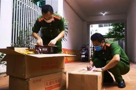 Lực lượng chức năng kiểm tra và thu giữ số lượng bánh Trung thu không rõ nguồn gốc. (Ảnh: TTXVN phát)