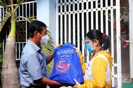 Đại diện Hội đồng nhân dân Tp. Hồ Chí Minh trao quà tặng và động viên công nhân ở trọ, người lao động có hoàn cảnh khó khăn ở Quận 8. (Ảnh: Thanh Vũ/TTXVN)