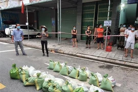 Số gạo do Chính phủ cấp được ưu tiên phát trước cho người dân ở trọ tại các phường "vùng đỏ đậm đặc" tại Bình Dương. (Ảnh: TTXVN phát)