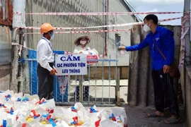 Chương trình trao tặng nhu yếu phẩm và vật tư y tế cho bà con tại các khu phong tỏa ở quận Bình Thủy, Cần Thơ. (Ảnh: TTXVN phát)