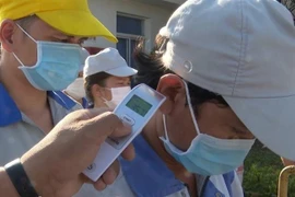 Công ty TNHH ắc quy CSB Việt Nam (KCN Nhơn Trạch 1, Đồng Nai) thực hiện đo kiểm tra thân nhiệt đối với mọi công nhân ra vào. (Ảnh: Công Phong/TTXVN)