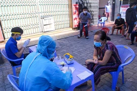 Thu thập thông tin người dân trước khi lấy mẫu xét nghiệm SARS-CoV-2 trong ngày đầu thực hiện “ai ở đâu thì ở đó.” (Ảnh: Trần Lê Lâm/TTXVN)