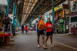 Người dân đeo khẩu trang và tấm chắn nhằm ngăn chặn sự lây lan của dịch COVID-19 khi mua sắm tại một khu chợ ở Manila, Philippines ngày 16/8/2020. (Ảnh: THX/TTXVN)