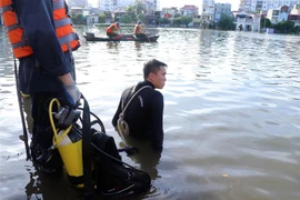 Lực lượng tìm kiếm cứu nạn tìm kiếm hai cháu trên hồ Tiên Nga. (Ảnh: Hoàng Ngọc/TTXVN)