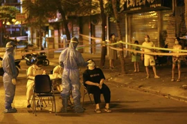 Lấy mẫu xét nghiệm cho người trong khu vực có ca nhiễm COVID-19 trên phố Trần Đại Nghĩa. (Ảnh: Hoàng Hiếu/TTXVN)