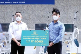Đại diện Công ty Phú Long (trái) trao tặng Hội Đông y Thành phố Hồ Chí Minh 1,7 tỷ đồng. (Ảnh: Xuân Khu/TTXVN)