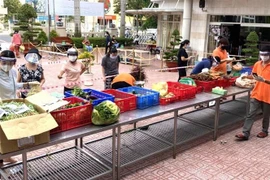 Người dân thực hiện 5K tại điểm bán hàng hóa thiết yếu bình ổn của Tổng công ty Công nghiệp thực phẩm Đồng Nai (Dofico) ở thành phố Biên Hòa. (Ảnh: TTXVN phát)