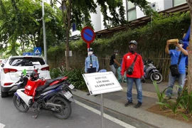 Điểm chung chuyển, giao hàng giữa khách hàng và người giao hàng (shipper) tại khu dân cư Hà Đô, Quận 10 trong những ngày giãn cách xã hội phòng, chống dịch COVID-19. (Ảnh: Thanh Vũ/TTXVN)