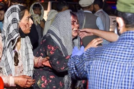 Nhân viên y tế hỗ trợ người bị thương trong vụ nổ bên ngoài sân bay quốc tế ở Kabul, Afghanistan. (Ảnh: AFP/TTXVN)