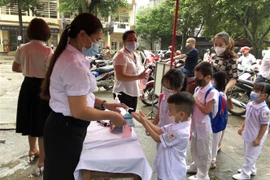 Học Trường Tiểu học Minh Khai, thành phố Hà Giang được do thân nhiệt và sát khuẩn trước khi vào lớp. (Ảnh: Nguyễn Chiến/TTXVN)