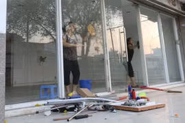 Cư dân block A, chung cư Carina Plaza trở về thu dọn để mở cửa lại quán cà phê Yuki ở tầng 1. (Ảnh: Thanh Vũ/TTXVN)
