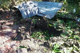 Vụ nổ tại Cà Mau khiến mặt đất bị biến dạng, tạo thành hố lớn. (Ảnh: Thế Anh/TTXVN)