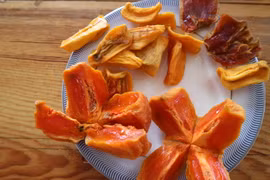 Hồng sấy bằng công nghệ Hàn Quốc có màu vàng, bên trong ruột hồng vẫn vàng đậm, hơi đỏ và mềm dẻo không khác hồng chín cây. (Ảnh: Nguyễn Dũng/TTXVN)