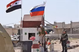 Quốc kỳ Syria và quốc kỳ Nga tại khu vực Abu Duhur, tỉnh Idlib, Syria ngày 25/9. (Ảnh: AFP/TTXVN)