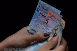 Kiểm tiền bolivar của Venezuela tại Caracas ngày 20/8. (Ảnh: THX/TTXVN)