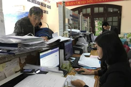 Bộ phận một cửa Bảo hiểm xã hội tỉnh Vĩnh Phúc tạo thuận lợi cho khách hành giao dịch giải quyết chế độ bảo hiểm y tế. (Ảnh: Nguyễn Thảo/TTXVN)