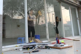 Cư dân block A, chung cư Carina Plaza trở về thu dọn để mở cửa lại quán cà phê Yuki ở tầng 1. (Ảnh: Thanh Vũ/TTXVN)
