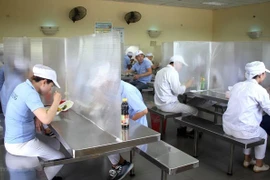 Nhà ăn của công nhân có vách ngăn, đảm bảo giãn cách. (Nguồn: TTXVN)