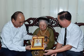 Chủ tịch nước Nguyễn Xuân Phúc đến thăm và tặng quà cho người có công. (Ảnh: Thống Nhất/TTXVN)