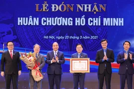 Thủ tướng Nguyễn Xuân Phúc, Chủ tịch Hội đồng Thi đua-Khen thưởng Trung ương trao tặng Huân chương Hồ Chí Minh lần thứ 3 cho Đoàn Thanh niên Cộng sản Hồ Chí Minh. (Ảnh: Trọng Đức/TTXVN)