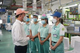 Tổng Giám đốc Bảo hiểm xã hội Việt Nam Nguyễn Thế Mạnh kiểm tra việc hỗ trợ người lao động tại Công ty ToTo Việt Nam. (Ảnh: PV/Vietnam+)