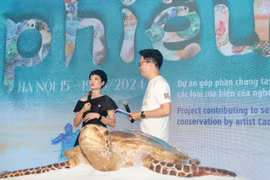 Nghệ sỹ Cao Thanh Thà (trái) phát biểu khai mạc triển lãm. (Ảnh: PV/Vietnam+)