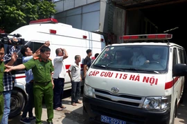 Xe cứu thương đưa thi thể các nạn nhân ra ngoài (Ảnh: PV/Vietnam+) 