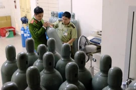 Cảnh sát kiểm tra các bình chứa khí cười tối 23/3 (Ảnh: PV/Vietnam+) 
