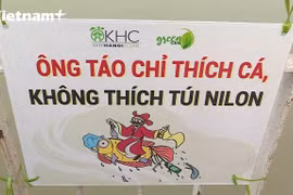 Tình nguyện viên nước ngoài cùng dọn rác nơi thả cá ông Công ông Táo. (Ảnh: Minh Anh/Vietnam+)